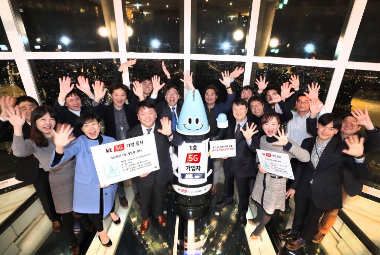 Lota, an AI robot and the first subscriber to KT’s 5G network commercial service, cheers with KT officials at the Lotte World Tower on December 1. PHOTO from KT Corp.