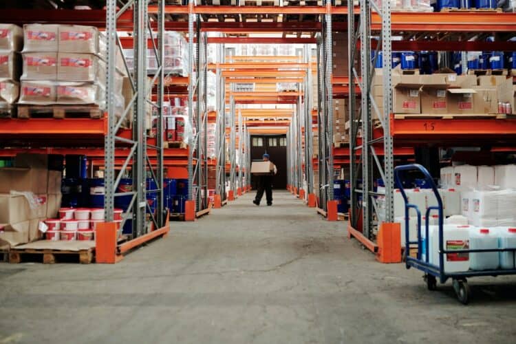 Photo by Tiger Lily: https://www.pexels.com/photo/man-standing-in-an-aisle-of-a-warehouse-carrying-a-box-4483774/