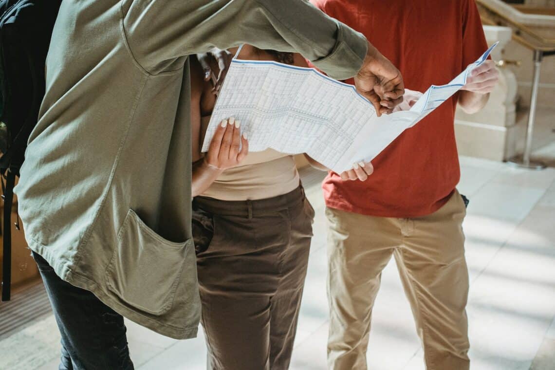 Photo by William  Fortunato : https://www.pexels.com/photo/anonymous-diverse-tourists-exploring-map-during-trip-6140449/