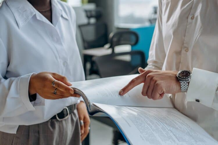 Photo by Mikhail Nilov: https://www.pexels.com/photo/colleagues-standing-in-white-long-sleeve-shirts-discussing-and-reading-a-financial-report-8297478/