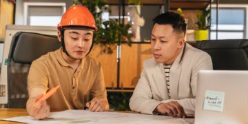 Photo by ANTONI SHKRABA production: https://www.pexels.com/photo/construction-worker-and-an-office-worker-looking-at-papers-together-in-an-office-8278910/