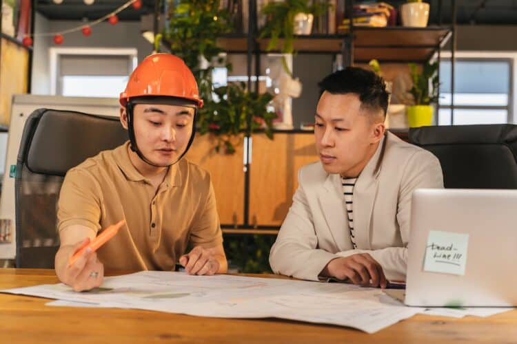Photo by ANTONI SHKRABA production: https://www.pexels.com/photo/construction-worker-and-an-office-worker-looking-at-papers-together-in-an-office-8278910/