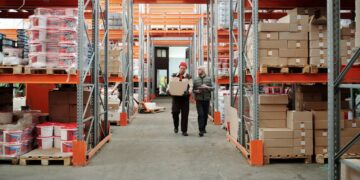 Photo by Tiger Lily: https://www.pexels.com/photo/workers-walking-along-aisle-in-warehouse-4487383/