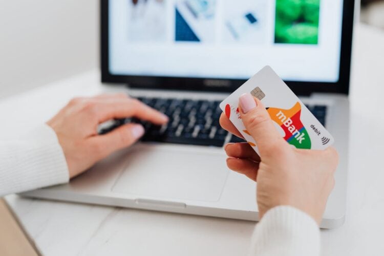 Photo by Photo By: Kaboompics.com: https://www.pexels.com/photo/close-up-shot-of-a-person-using-a-laptop-while-holding-a-credit-card-5717993/