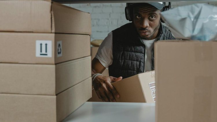 Photo by Tima Miroshnichenko: https://www.pexels.com/photo/a-man-standing-behind-a-shelf-with-cardboard-boxes-6170408/